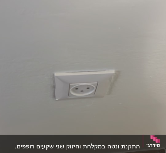 שקע חשמל בקיר לבן מעל רצפה